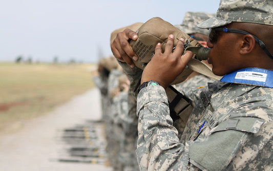 U.S. military servicemen drinking water from canteens.