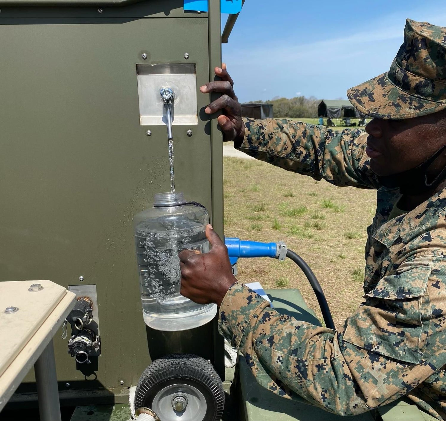U.S. military serviceman uses RussKap OASIS to fill canteen with water from air.